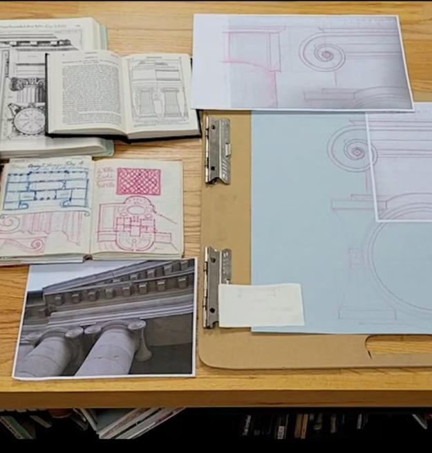 Manuals, photos, and measuring instruments sit on a wooden desk
