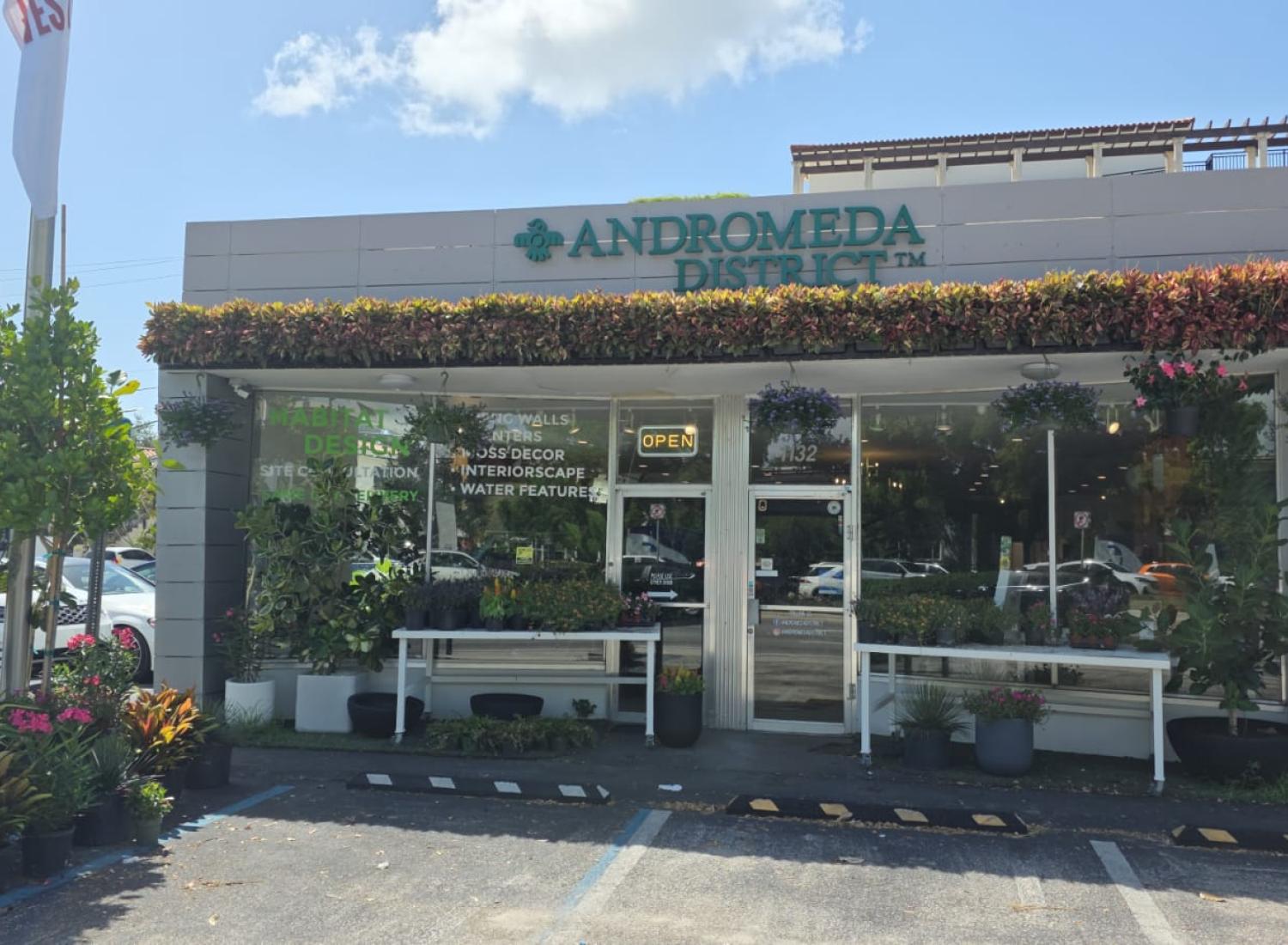 Storefront for Andromeda District with plants displayed outside the entrance.