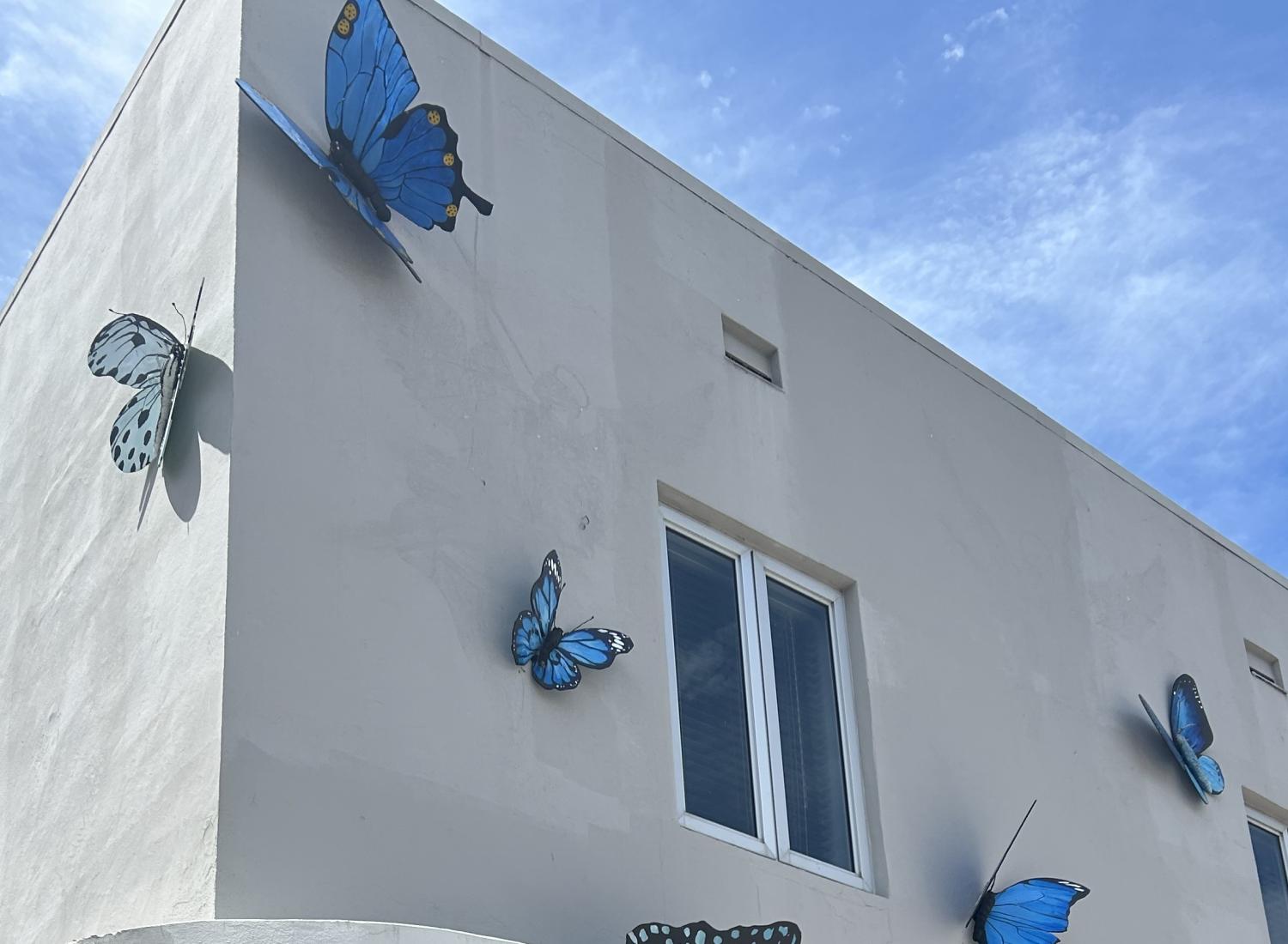 Blue butterflies attached to an office building with blue sky