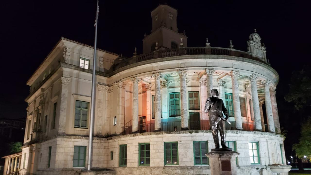 City Hall on a dark night, lit up with pink and blue lights