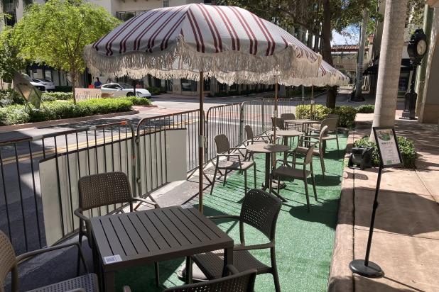 Parking Day street spot with lawn and chairs and red line pattern umbrellas