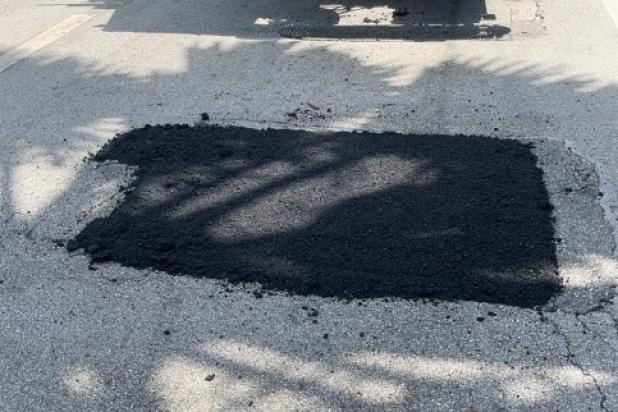 Fixed and smoothed black patch on street in a tree's shade