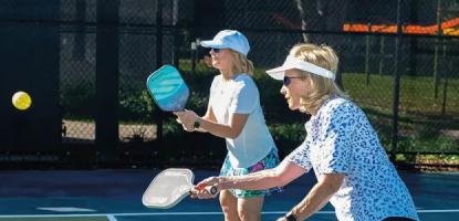 Two ladies playing pickleball
