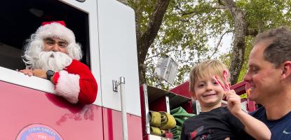 Santa Claus waving from a firetruck
