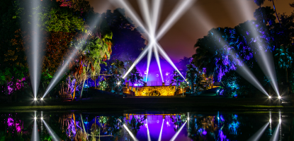 Purple and white lights make the arch across the water glow
