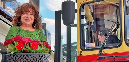 On sunny day with clouds, a woman with a green shirt sits on her wheelchair smiling in front of the trolley