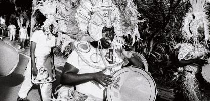 Black and white photo of musician in Bahamian cultural outfit