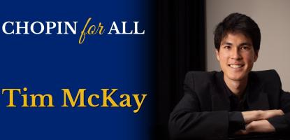 Tim McKay seated a closed piano, smiling