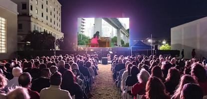 Audience outside looking at a large projection