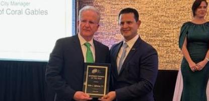 Peter Iglesias and presenter hold up award