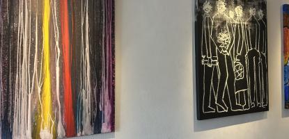 3 different paintings hanging on white wall, abstract yellow and red, line drawings, and colorful shapes