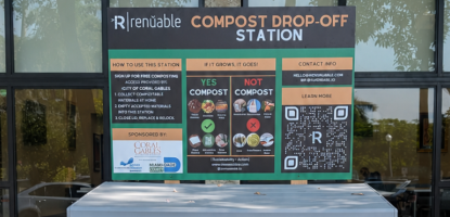 Wide compost bin on stone patch on mulch with sign that explains compost rules