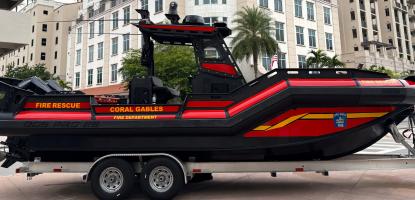 Fire Rescue Boat in front of large building with cloudy sky