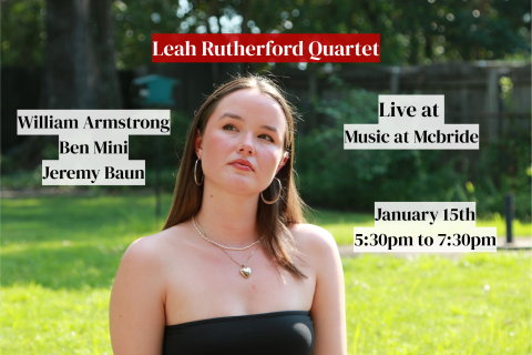 Leah Rutherford looking up in a black top with sunlit green grass and shaded trees in the background