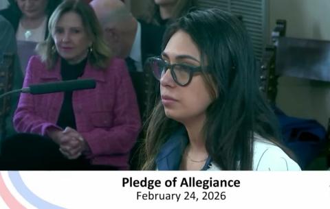 Mairet Murias in business attire standing at the podium