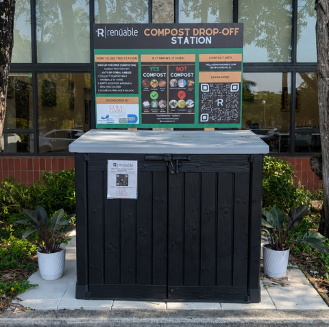 Wide compost bin on stone patch on mulch with sign that explains compost rules