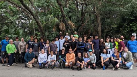 Large group photo of people in front of trees