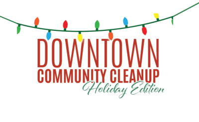 Christmas lights hang above Downtown Community Cleanup Holiday Edition text