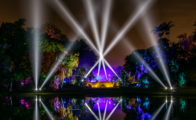 Purple and white lights make the arch across the water glow