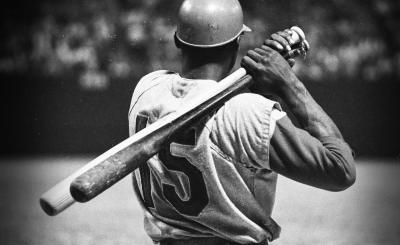 Film poster, black and white photo with baseball player facing away with two baseball bats behind him 