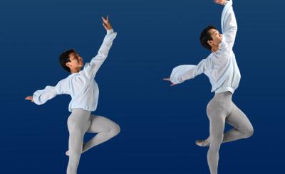 Two ballet dancers posed on one leg in a blue background wearing grey tights and a flowy white shirt