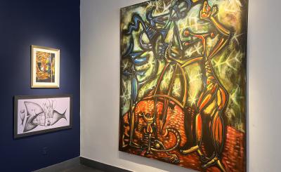 Large abstract painting titled Perspective featuring stylized, elongated figures in glowing gold, orange, and blue tones against a dark, textured background, displayed in a modern gallery corner beside two smaller framed artworks.