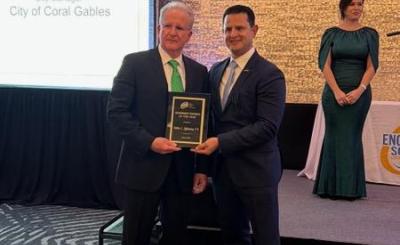 Peter Iglesias and presenter hold up award