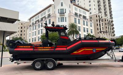 Fire Rescue Boat in front of large building with cloudy sky