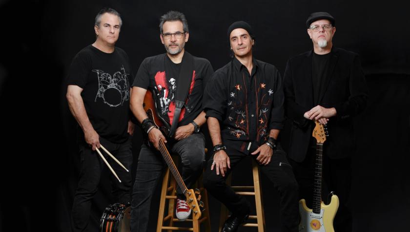 Boys Don't Cry members in dark clothing pose with instruments