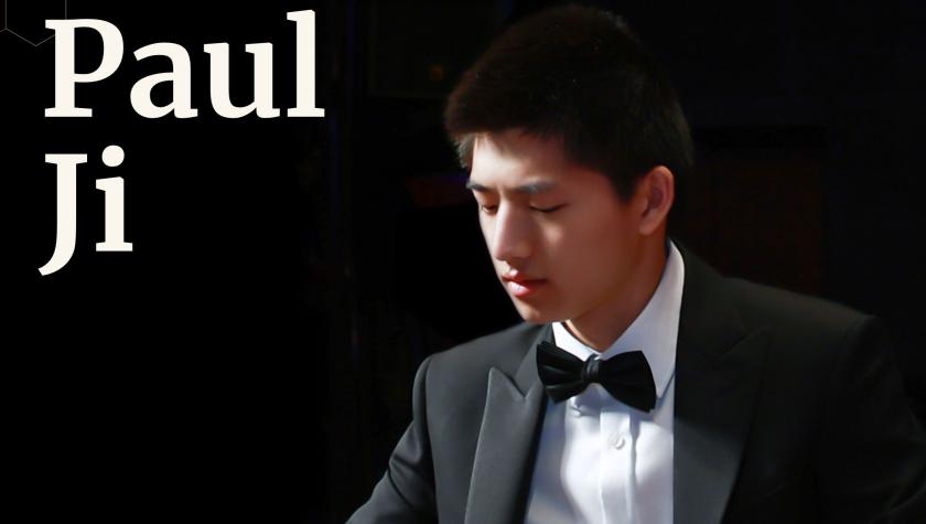 Paul Ji in a tux looking down playing the piano